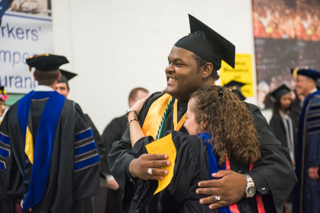 A faculty mentor congratulates Da’Kuawn Johnson, highlighted in UMBC's Class of 2017. 