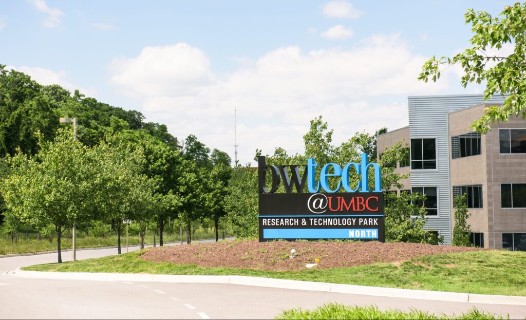 Sign reading "bwtech@UMBC Research & Technology Park -- NORTH" next to trees and office buildings.