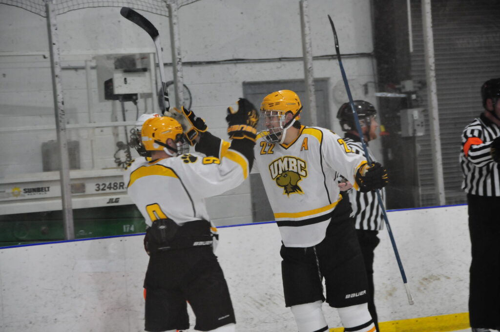 Ryan Atkinson playing hockey with teammate