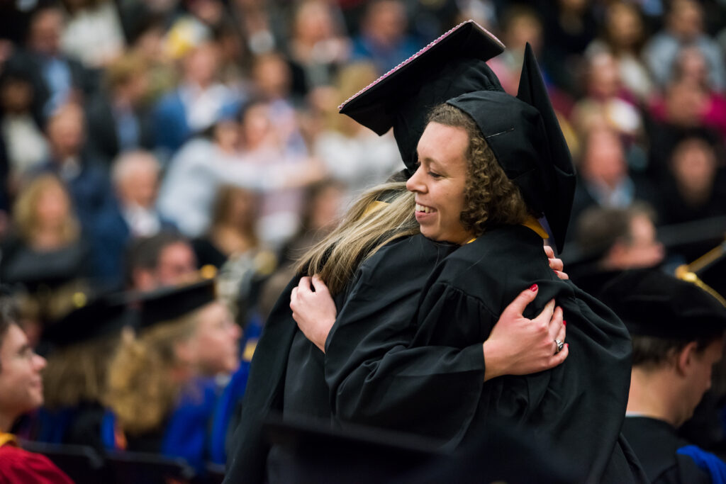 UMBC student and faculty exchanged hugs during Winter Commencement.