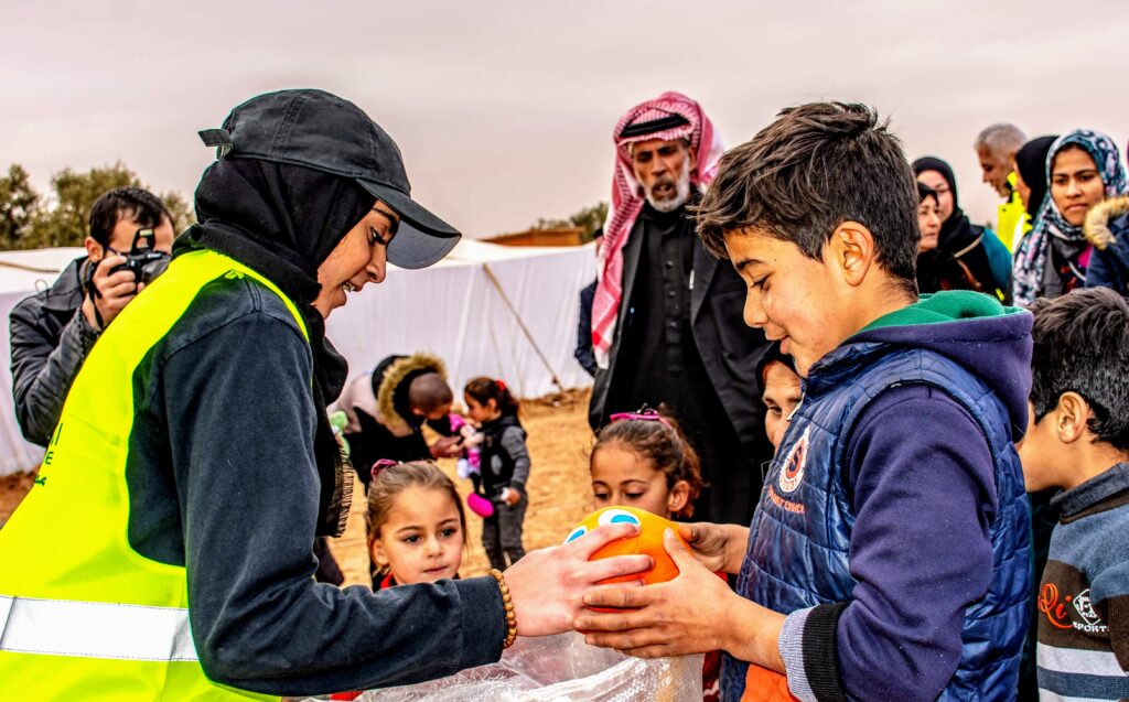 Maheen Haq giving out toys to children in a Syrian refugee camp. Photo courtesy of Haq with permission from Helping Hand for Relief and Development.