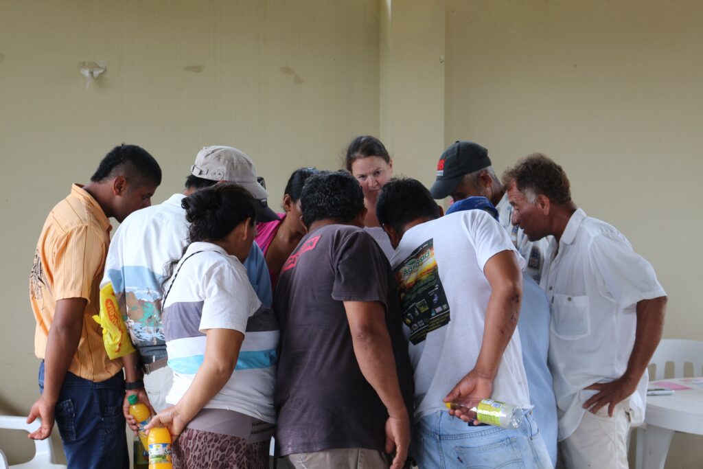 Maggie Holland (center, rear), geography and environmental systems, interviews a group of farmers in the Amazon about the forests on their properties. Photo courtesy Maggie Holland.