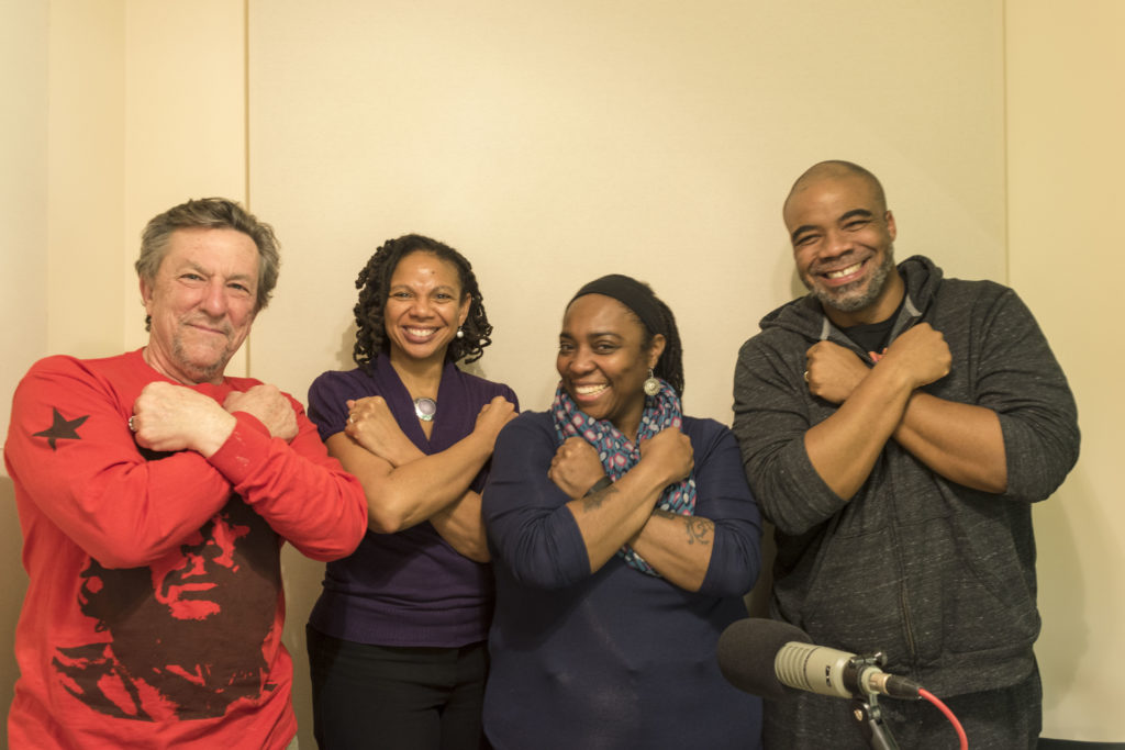 Four adults gather for a portrait and cross their arms over their chests in the style of the film The Black Panther.