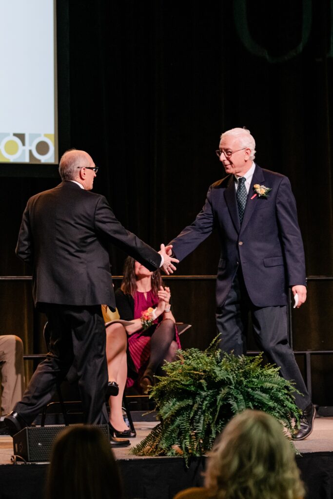 Bill LaCourse and Yonathan Zohar shake hands on stage